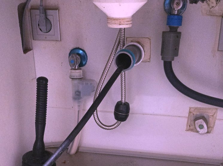 Manguera introducida en la tubería de un fregadero para su limpieza